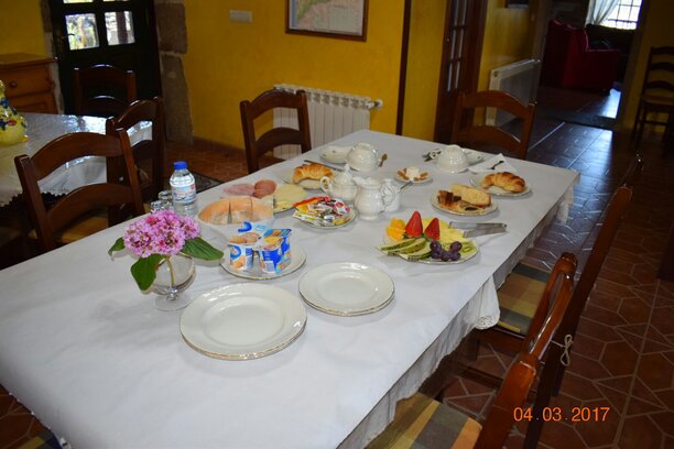 Desayuno en el porche con vistas al jardín de la casa rural